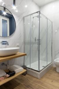 uma casa de banho com uma cabina de duche em vidro e um lavatório. em Casa Maya em Salerno