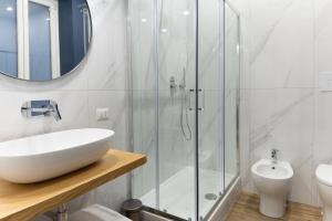 a white bathroom with a sink and a shower at Casa Maya in Salerno