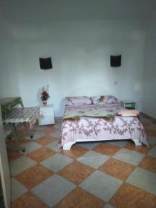 a bedroom with a bed and a checkered floor at Chez Bablou in Grand-Baie