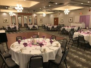a banquet hall with tables and chairs with white tablecloths at Holiday Inn Martinsburg by IHG in Martinsburg +37 photos