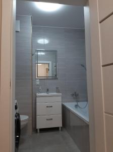 a bathroom with a sink and a toilet and a mirror at Apartament Garbary 84 in Poznań