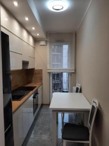 a kitchen with a white table and chairs in it at Apartament Garbary 84 in Poznań
