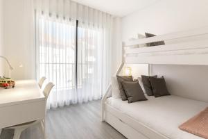 a white bedroom with a bunk bed and a desk at Consolação Supertubos Beach Apartment in Consolação