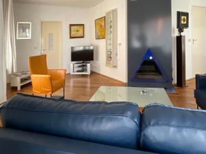 un salon avec un canapé bleu et une table en verre dans l'établissement Vakantiewoning Afterdaan, à Elim