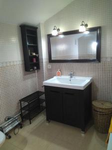 a bathroom with a sink and a mirror at Ático Dúplex con vistas in Murcia +18 photos
