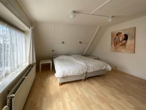 - une chambre avec un lit et une peinture murale dans l'établissement Vakantiewoning Afterdaan, à Elim