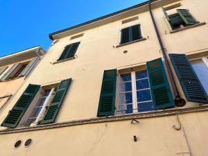 a building with green shutters on it at Lovely nest in Parma centro in Parma