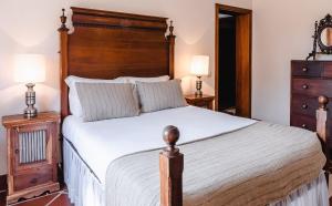 a bedroom with a large bed with a wooden headboard at Quinta Da Torre - Óbidos Country House in Óbidos