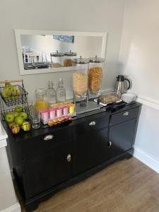 um armário preto com comida em cima em The Roxburgh Guest Accommodation em Berwick-Upon-Tweed