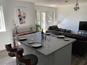 Tanllan Apartment في كالالندر: مطبخ وغرفة معيشة مع جزيرة كبيرة مع طاولة