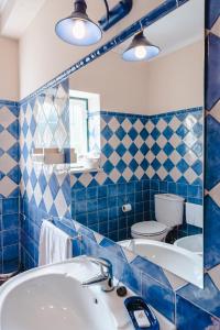 uma casa de banho em azulejos azuis com um lavatório e um WC em Quinta Da Torre - Óbidos Country House em Óbidos