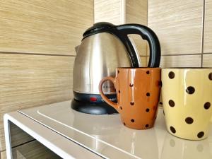 a tea kettle and two cups sitting on a counter at Adriatique Apartments in Dobra Voda