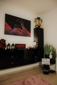 a living room with a black dresser and a tv at Red Deluxe Apartament in Kościerzyna