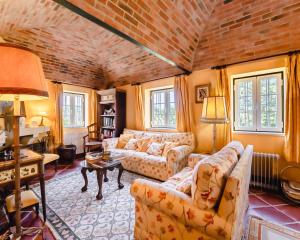 a living room with two couches and a brick wall at Quinta Da Torre - Óbidos Country House in Óbidos