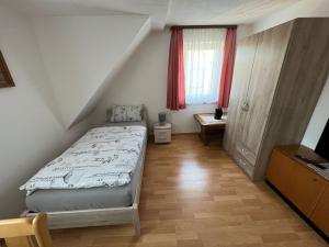 a small bedroom with a bed and a window at Ferienwohnung Frankenhof in Bad Steben