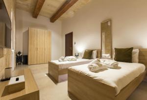 a bedroom with two beds with towels on them at Rabat Farmhouse with pool and cave in Għajn Qajjied