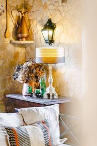 a table with a lamp and a vase of flowers at Quinta Da Torre - Óbidos Country House in Óbidos