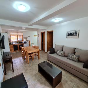 una sala de estar con un sofá y una mesa en Golondrinas - Andarlibre, en San Martín de los Andes