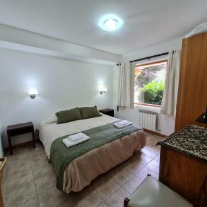 Un dormitorio con una cama con dos toallas encima. en Golondrinas - Andarlibre, en San Martín de los Andes