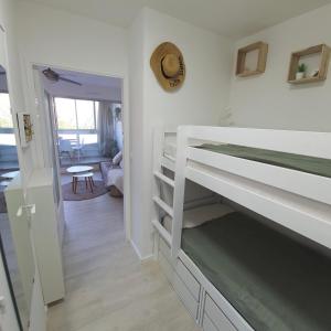 a bedroom with a bunk bed and a living room at Blue Sky La Grande Motte Studio -Pool-5min Beach -Queensizebed -WiFi in La Grande-Motte