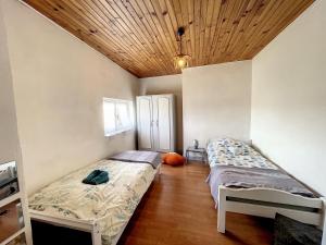 een slaapkamer met 2 bedden en een houten plafond bij APPARTEMENT PLEIN DE CHARME 2CH in Gannat