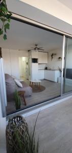a view of a bedroom and a kitchen through a window at Blue Sky La Grande Motte Studio -Pool-5min Beach -Queensizebed -WiFi in La Grande-Motte