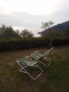 a lawn chair sitting on the grass near the water at VILLA ROSA CON SPLENDIDA VISTA MARE in Bonassola