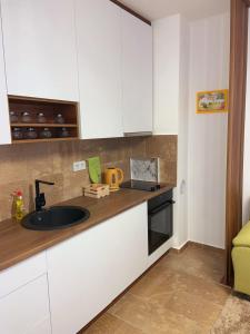 una cocina con armarios blancos y fregadero en Apartment Aria en Travnik