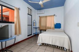 Schlafzimmer mit einem Bett und einem Flachbild-TV in der Unterkunft Hotel Costamar, Puerto Escondido in Puerto Escondido