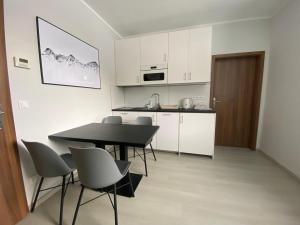 een keuken en eetkamer met een tafel en stoelen bij Apartmán v Koutech in Kouty