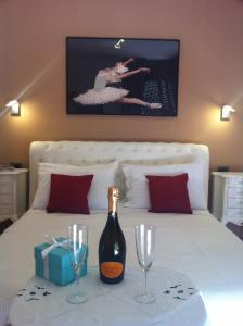 a bed with a bottle of wine and two glasses at Alla Terrazza Apartment in Verona