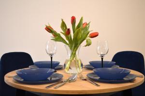 stół z miskami i wazon z kwiatami w obiekcie Apartament Centrum Białystok w mieście Białystok