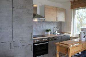 a kitchen with stainless steel appliances and a wooden table at Brandt in Kirchdorf