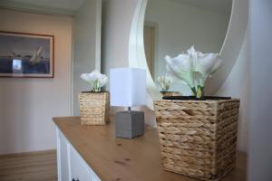 two vases with flowers on a table with a lamp at Brandt in Kirchdorf