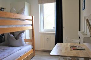 1 dormitorio con litera, mesa y ventana en Brandt, en Kirchdorf