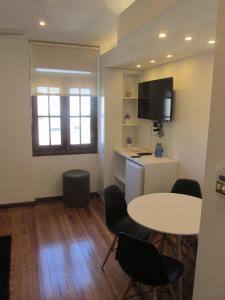 Cette chambre dispose d'une table, de chaises et d'une télévision. dans l'établissement Apartamentos en el palacio salvo, à Montevideo