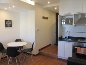 a kitchen with a table and chairs and a table at Apartamentos en el palacio salvo in Montevideo