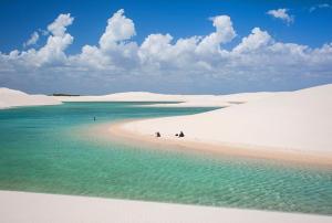 two people walking on a beach in the sand at Deliciosa Casa de 5 qtos nos Lençóis Maranhenses in Barreirinhas