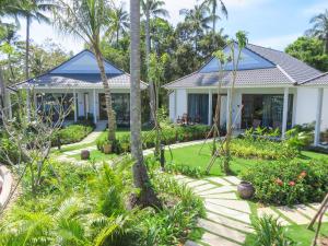 a house with a garden and palm trees at Kingo Retreat Resort in Phu Quoc