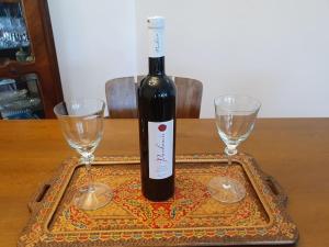 eine Flasche Wein zwischen zwei Gläsern auf dem Tisch in der Unterkunft Novi Escape 2 Beachfront 4 Star Apartment in Novi Vinodolski + 16 Fotos
