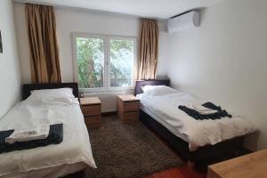 ein Schlafzimmer mit zwei Betten und einem Fenster mit Vorhängen in der Unterkunft Novi Escape 2 Beachfront 4 Star Apartment in Novi Vinodolski