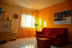 a living room with a red couch and a window at Casa Rosetta in Pescantina