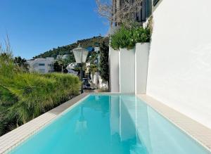 a large blue swimming pool next to a white building at Clifton Ezulwini in Cape Town