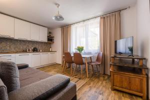 a living room with a kitchen and a table with chairs at Niemczukówka 1 - Smerek in Wetlina