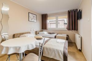 a room with two beds and a table and chairs at Wynajem pokoi w Sztutowie in Sztutowo