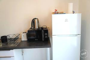 a kitchen with a microwave next to a refrigerator at Superbe appartement T2 de 50m2 près de Genève à Saint Julien en Genevois idéal pour couple avec 2 enfants jusqu'à 18 ans in Saint-Julien-en-Genevois +2 photos