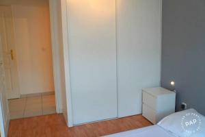 a bedroom with a white bed and a white dresser at Superbe appartement T2 de 50m2 près de Genève à Saint Julien en Genevois idéal pour couple avec 2 enfants jusqu'à 18 ans in Saint-Julien-en-Genevois