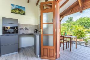 a kitchen with a wooden door and a table at AU DOMAINE DE COTON in Saint-Louis