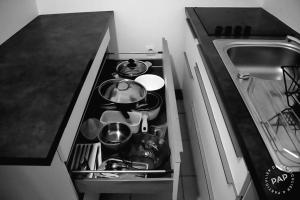 a kitchen drawer filled with pots and pans at Superbe appartement T2 de 50m2 près de Genève à Saint Julien en Genevois idéal pour couple avec 2 enfants jusqu'à 18 ans in Saint-Julien-en-Genevois