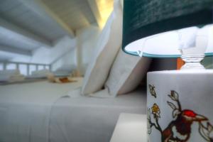 una lampada seduta su un tavolo accanto a una tazza di caffè di Corfu Centro Storico flat a Città di Corfù